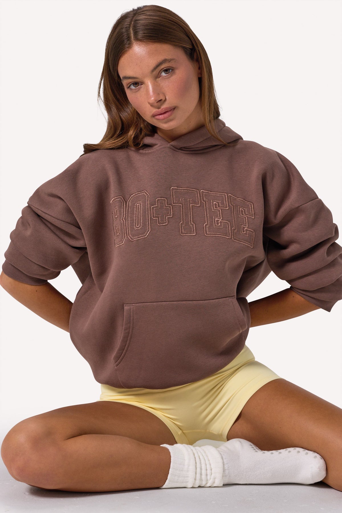 Bo+Tee model Lydia Butler wearing the CosyCoffeeRunWithLydsButler Hoodie in Cocoa Brushback sweat fabric perfect for gym commutes
