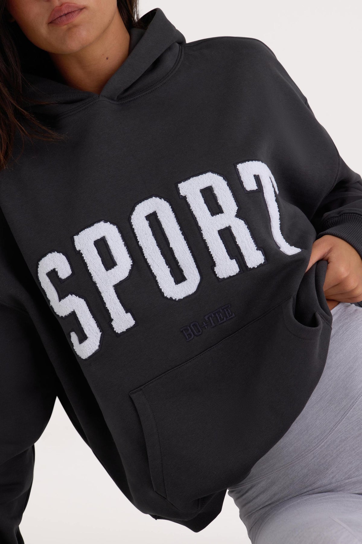 Bo+Tee model Kiele wearing the Varsity Hoodie in Black Cotton fabric perfect for running errands