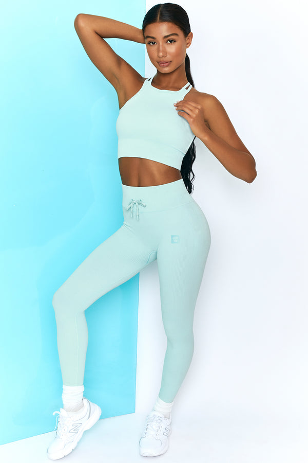 model wearing tie front gym leggings and crop top in light blue