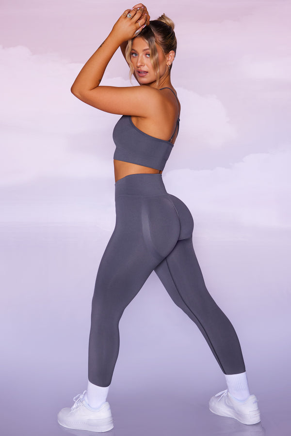 model posing to the side in curved waist seamless leggings in the shade grey