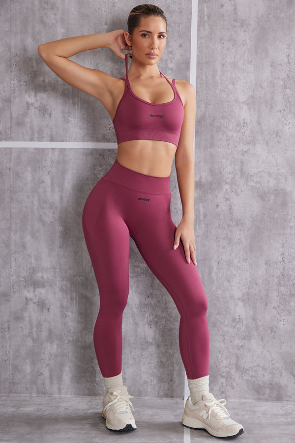 model wearing high waisted seamless leggings and sports bra set in dark rose