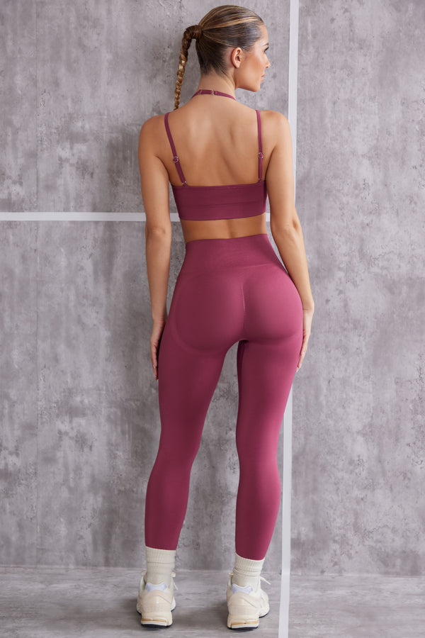 model showing back of high waisted seamless leggings and sports bra set in dark rose