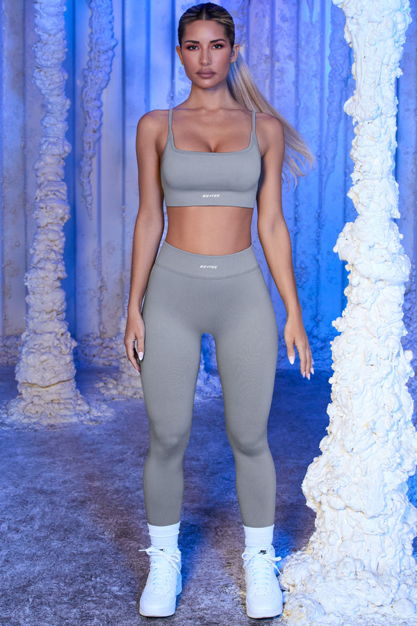 model wearing matching grey gym leggings and crop top